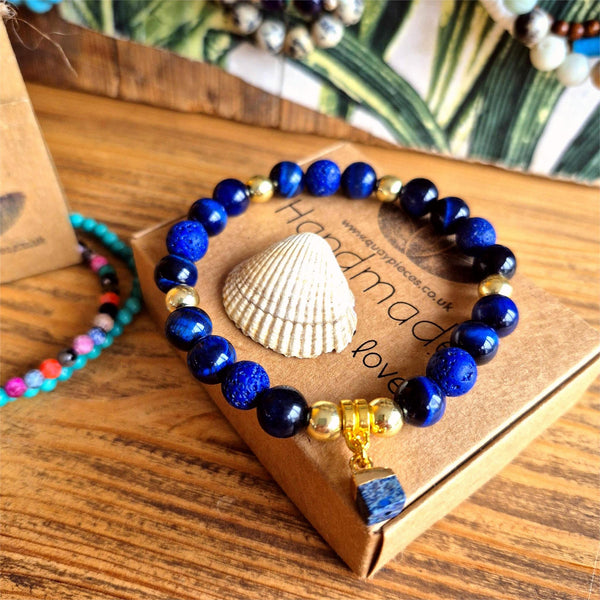 Beautiful 8mm navy blue tiger's eye bead bracelet featuring gold-plated accent beads and an elegant square stone charm. 