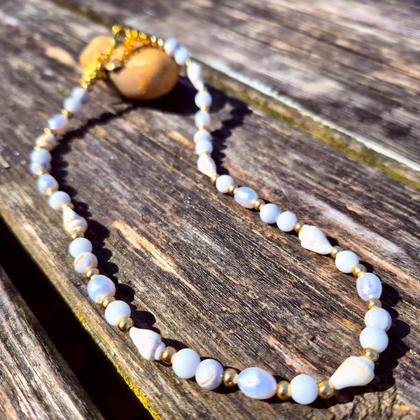 Gorgeous handmade short necklace features 4mm white jade beads &amp; white spiral shells paired with shining gold-plated beads and a secure lobster clasp. Plus a tiny gold spiral shell &amp; extension chain with cute fish charm completes the look. Measuring 43cm, it’s the perfect playful touch to wear solo or layered with your favourite pieces.