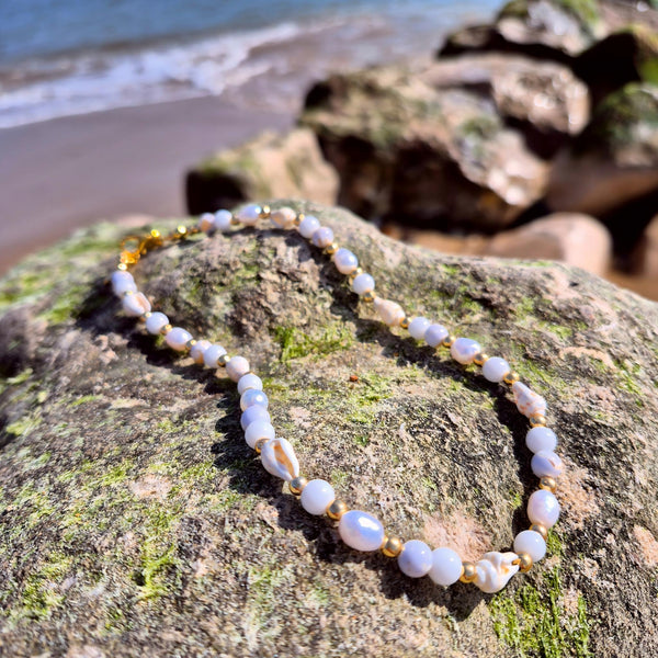 Gorgeous handmade short necklace features 4mm white jade beads &amp; white spiral shells paired with shining gold-plated beads and a secure lobster clasp. Plus a tiny gold spiral shell &amp; extension chain with cute fish charm completes the look. Measuring 43cm, it’s the perfect playful touch to wear solo or layered with your favourite pieces.