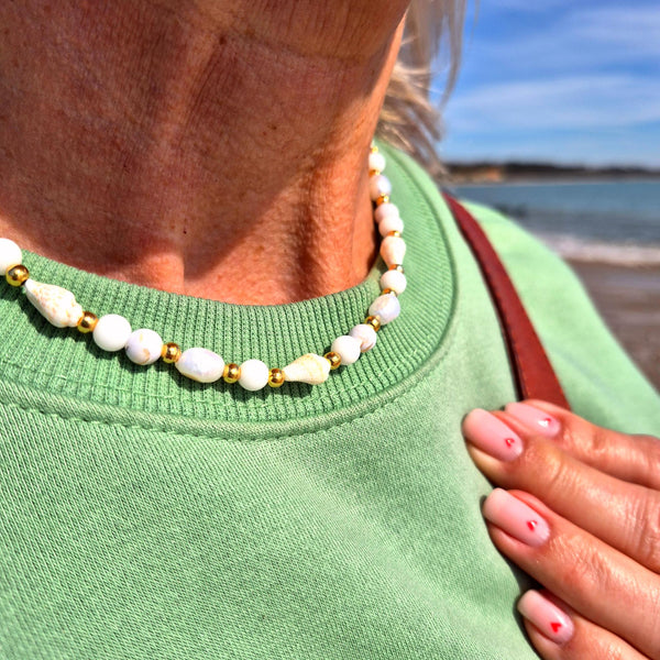 Gorgeous handmade short necklace features 4mm white jade beads &amp; white spiral shells paired with shining gold-plated beads and a secure lobster clasp. Plus a tiny gold spiral shell &amp; extension chain with cute fish charm completes the look. Measuring 43cm, it’s the perfect playful touch to wear solo or layered with your favourite pieces.