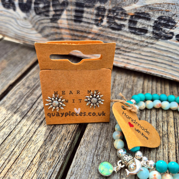 Sunburst flower stud earrings displayed on a brown cardboard hanger card with the brand name 'quaypieces.co.