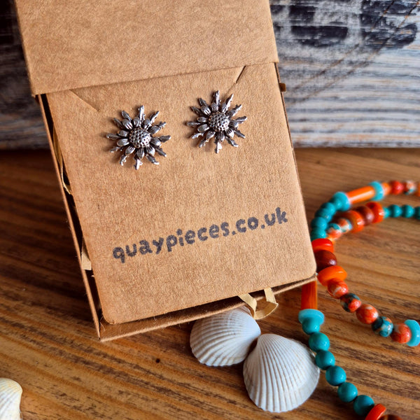 Sunburst stud earrings in silver-tone metal displayed on a brown kraft paper card that reads 'quaypieces.co.