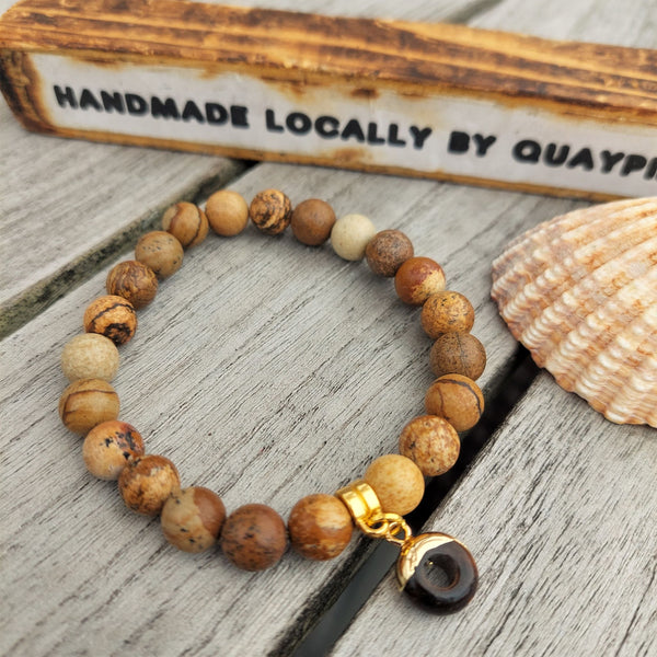 8mm Brown Marble Effect Natural Stone Bead Bracelet with gold plated circular charm  Elasticated, so will fit most adult wrists (measuring 71/2 in/19cm)  Perfect for wearing with those winter outfits & a lovely gift for friends or family  **Presented in lovely Kraft paper gift box with reusable organza pouch**