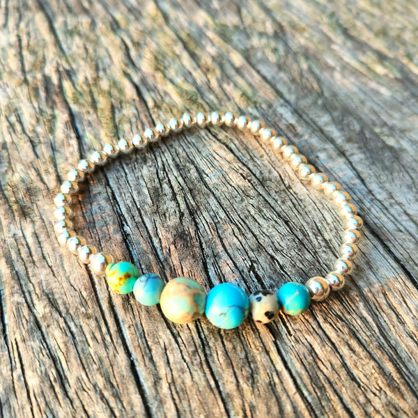 4mm Sterling Silver with ocean shades of blue natural stone & dalmatian Jasper beads﻿﻿  Super cute bracelet to wear alone or as a stack!  Elasticated, so will fit most adult wrists (measuring 7.5 in/19cm)  **Presented in lovely Kraft paper gift box with reusable organza pouch**  **Will not tarnish if cared for properly**