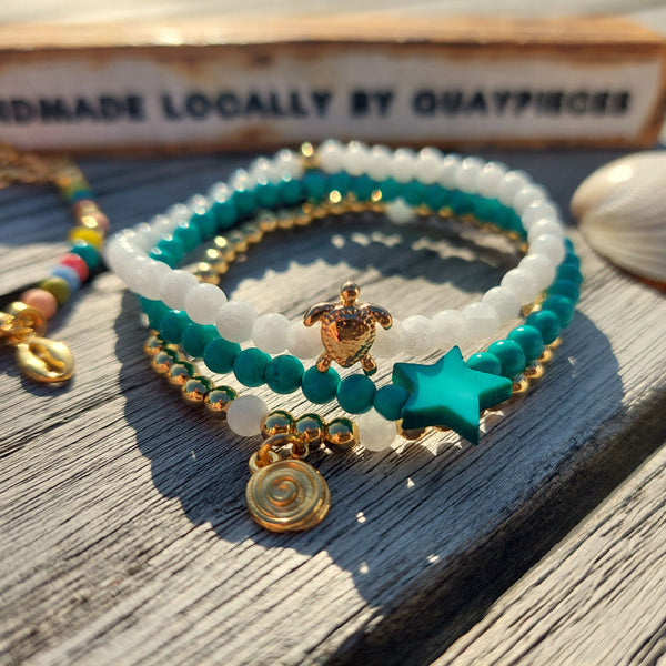 <p data-mce-fragment="1">Gorgeous Handcrafted Collection of 3 Delicate Beaded Bracelets</p> <p data-mce-fragment="1">Each Bracelet is individually designed, (1) 4mm natural white jade beads with cute 18k gold plated turtle (2) 4mm turquoise magnesite beads with star (3) 4mm 18k gold plated beads with hanging swirl charm</p> <p data-mce-fragment="1">Wear altogether or separately for a boho/Surf Chick look!</p>