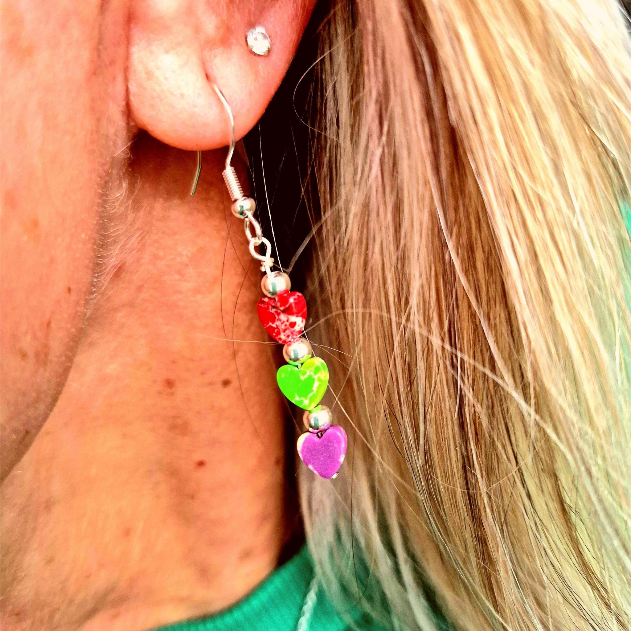 These super cute earrings are crafted from 925 Hall Marked Sterling Silver, featuring handmade sterling silver beads and 6mm marbled stone hearts in playful shades of purple, green, and red. Measuring 30mm from the hook’s base, they’re the perfect pop of colour to brighten your summer wardrobe. A delightful gift for a friend or a fun treat just for you!