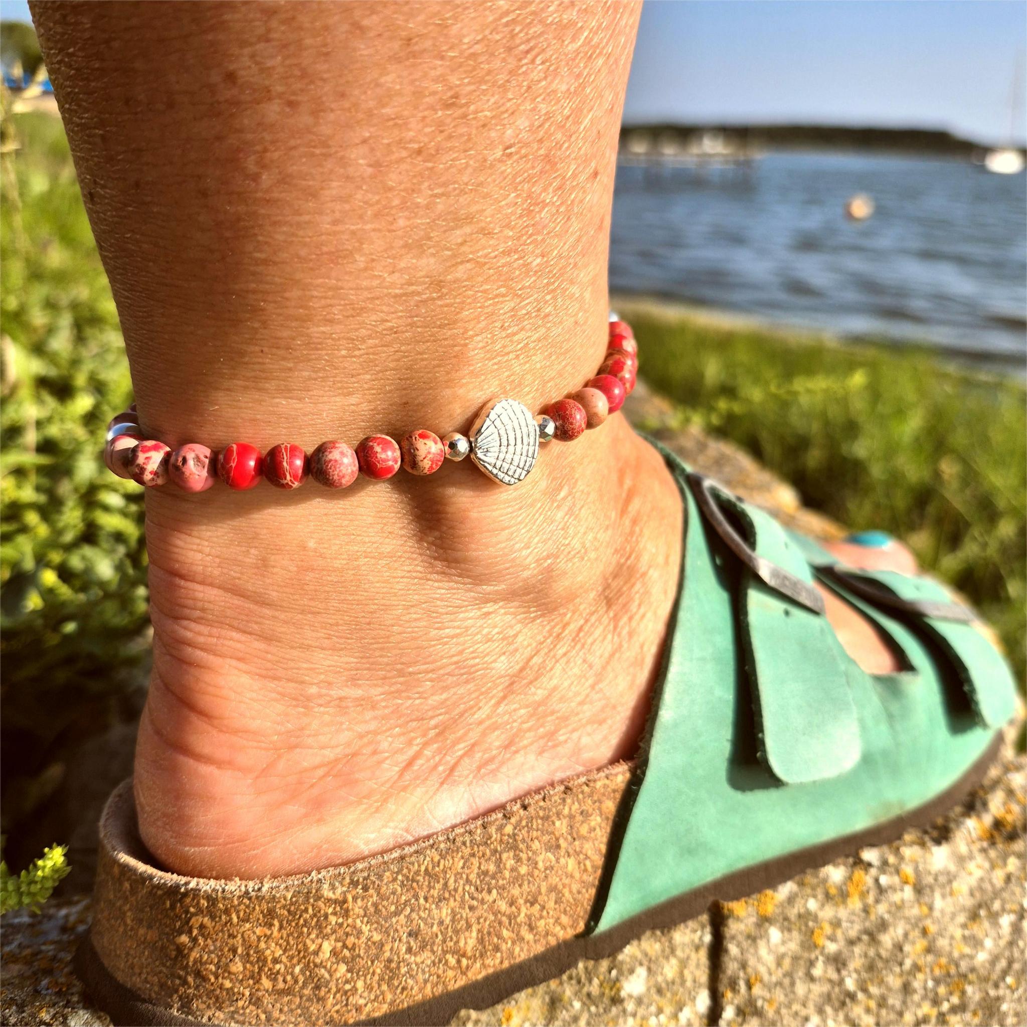 Beach vibes with this super cute stretch beach anklet, handmade with 6mm dark pink marbled imperial jasper stone beads &amp; silver plated shells plus hematite beads

Choose from sizes
M - elasticated at 23cm/9ins&nbsp;
or
L - elasticated at 25.4cm/10ins


Cool little gift for any surf chick!

**Presented in lovely Kraft paper gift box with reusable organza pouch**