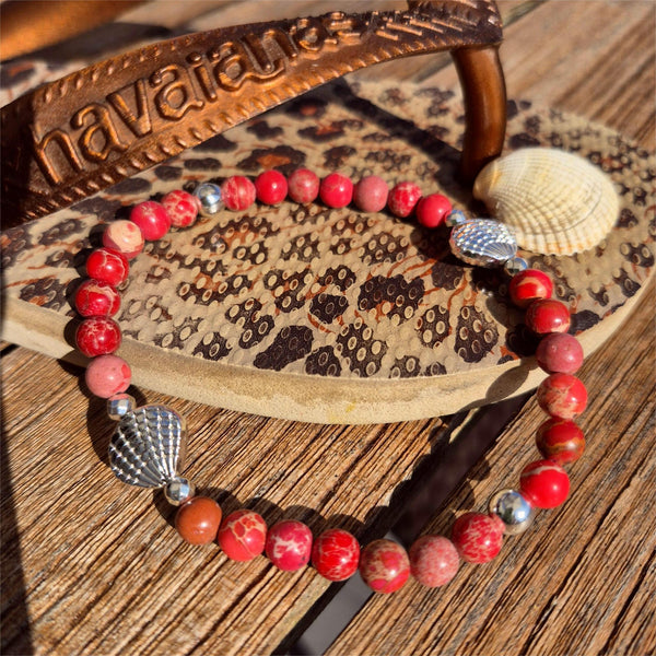 Beach vibes with this super cute stretch beach anklet, handmade with 6mm dark pink marbled imperial jasper stone beads &amp; silver plated shells plus hematite beads

Choose from sizes
M - elasticated at 23cm/9ins&nbsp;
or
L - elasticated at 25.4cm/10ins


Cool little gift for any surf chick!

**Presented in lovely Kraft paper gift box with reusable organza pouch**