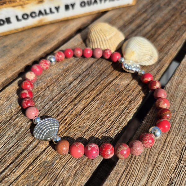 Beach vibes with this super cute stretch beach anklet, handmade with 6mm dark pink marbled imperial jasper stone beads &amp; silver plated shells plus hematite beads

Choose from sizes
M - elasticated at 23cm/9ins&nbsp;
or
L - elasticated at 25.4cm/10ins


Cool little gift for any surf chick!

**Presented in lovely Kraft paper gift box with reusable organza pouch**
