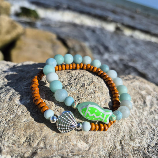 uper cool handcrafted collection of 2 Beaded Bracelets

Each Bracelet is individually designed one with 8m matt aqua amazonite beads &amp; the second with 4mm wood &amp; silver plated beads with cute shell charm.
A great summer combination!

Elasticated, so will fit most adult wrists (measuring 7.5 in/19cm


Perfect fun gift for sea lovers!

**Presented in lovely Kraft paper gift box with reusable organza pouch**