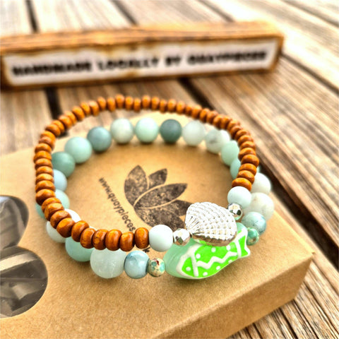 uper cool handcrafted collection of 2 Beaded Bracelets

Each Bracelet is individually designed one with 8m matt aqua amazonite beads &amp; the second with 4mm wood &amp; silver plated beads with cute shell charm.
A great summer combination!

Elasticated, so will fit most adult wrists (measuring 7.5 in/19cm


Perfect fun gift for sea lovers!

**Presented in lovely Kraft paper gift box with reusable organza pouch**