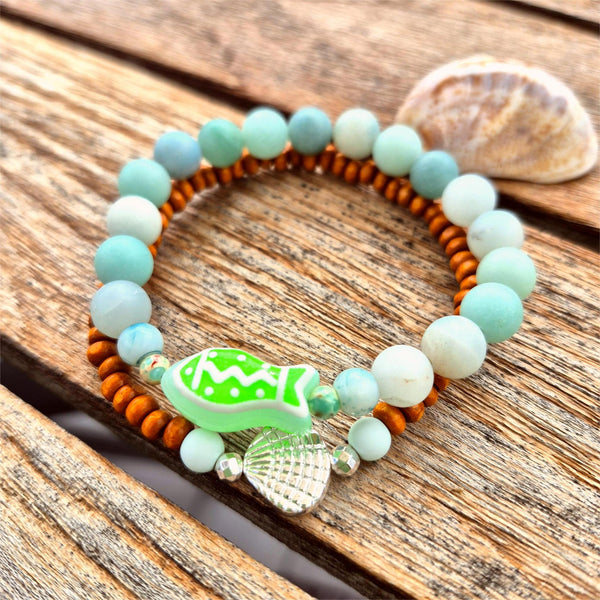 uper cool handcrafted collection of 2 Beaded Bracelets

Each Bracelet is individually designed one with 8m matt aqua amazonite beads &amp; the second with 4mm wood &amp; silver plated beads with cute shell charm.
A great summer combination!

Elasticated, so will fit most adult wrists (measuring 7.5 in/19cm


Perfect fun gift for sea lovers!

**Presented in lovely Kraft paper gift box with reusable organza pouch**