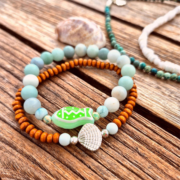 uper cool handcrafted collection of 2 Beaded Bracelets

Each Bracelet is individually designed one with 8m matt aqua amazonite beads &amp; the second with 4mm wood &amp; silver plated beads with cute shell charm.
A great summer combination!

Elasticated, so will fit most adult wrists (measuring 7.5 in/19cm


Perfect fun gift for sea lovers!

**Presented in lovely Kraft paper gift box with reusable organza pouch**