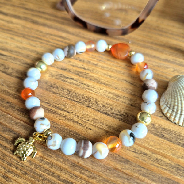 Beaded bracelet with a turtle charm on a wooden surface