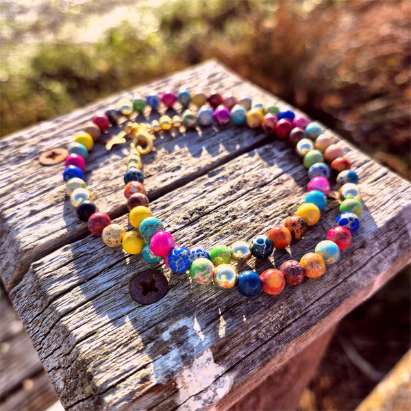 Colorful beaded necklace on a wooden surface with a natural background