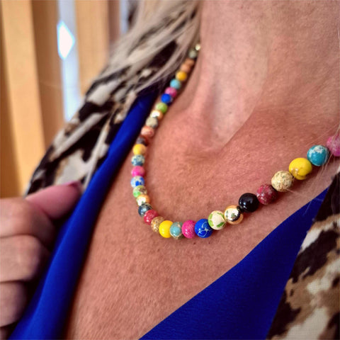 Colorful beaded necklace worn by a person with a blurred background