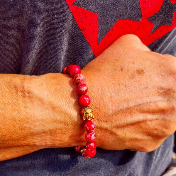 Person wearing a red beaded bracelet with a star-patterned shirt