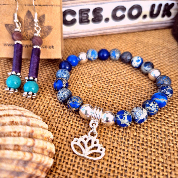 Beaded bracelet with silver lotus charm and matching earrings on a textured surface with 'CES.CO.UK' branding.