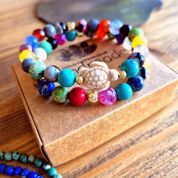 Colorful beaded bracelet with a turtle charm on a wooden box