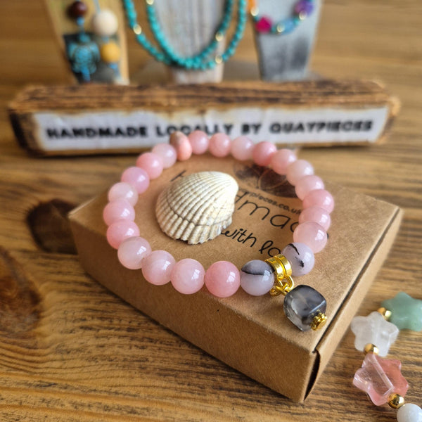 Pixie is the perfect pop of colour for your wrist! This super cute bracelet features delicate 8mm pink stone beads paired with a charming grey square glass accent &amp; opal disc that adds just the right touch of sophistication. Whether you're brightening up your everyday look or searching for a thoughtful gift, this little beauty delivers instant joy and style.