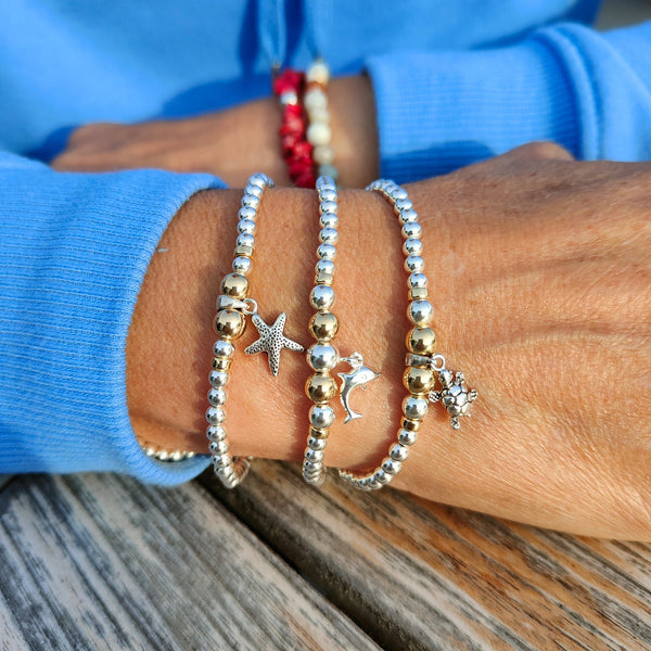 ﻿﻿Lovely Handmade Sterling Silver & gold filled bead bracelets with sea creature charm.  4mm Sterling Silver & gold filled beads with choice of Dolphin, Turtle & Starfish charm  Elasticated, so will fit most adult wrists (measuring 71/2 in/19cm)  Super cute bracelet to wear alone or as a stack!  Presented in lovely Kraft paper gift box with pretty reusable organza pouch