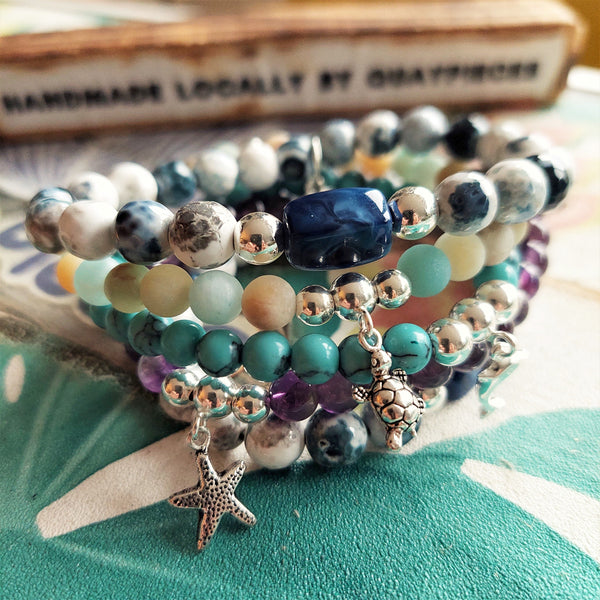 ﻿8mm semi precious faceted cut stone bead bracelet in white/grey/navy opal colour with blue rectangle charm & made with love heart (nickel free)  ﻿Elasticated, so will fit most adult wrists (measuring 71/2 in/19cm)  Lovely gift for friends or family  **Presented in lovely Kraft paper gift box with reusable organza pouch**